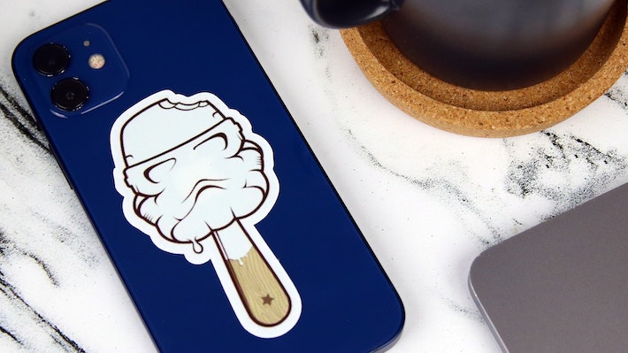 Die cut white vinyl sticker with stormtrooper lolly design applied to an iPhone on a table