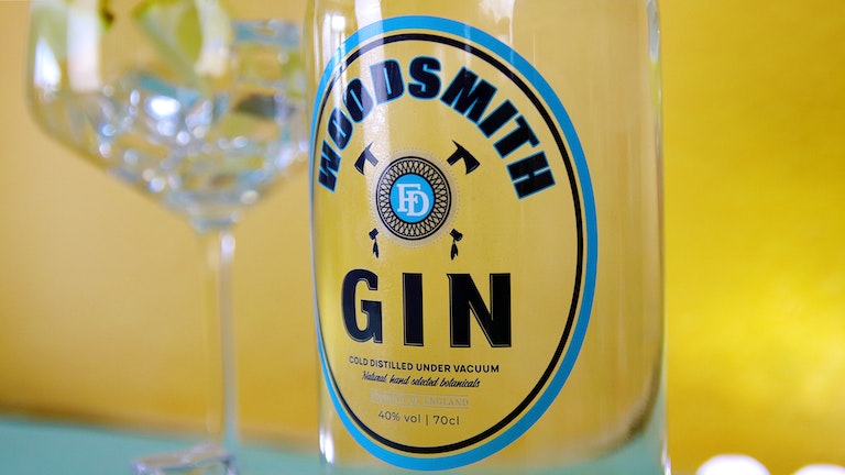 Oval clear sticker with gin logo applied to a clear gin bottle