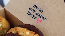 Oval clear sticker applied to a cardboard box filled with cookies stating you've got great taste