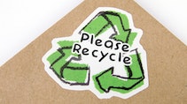 Die cut eco-friendly stickers with recycling design applied to a cardboard envelope