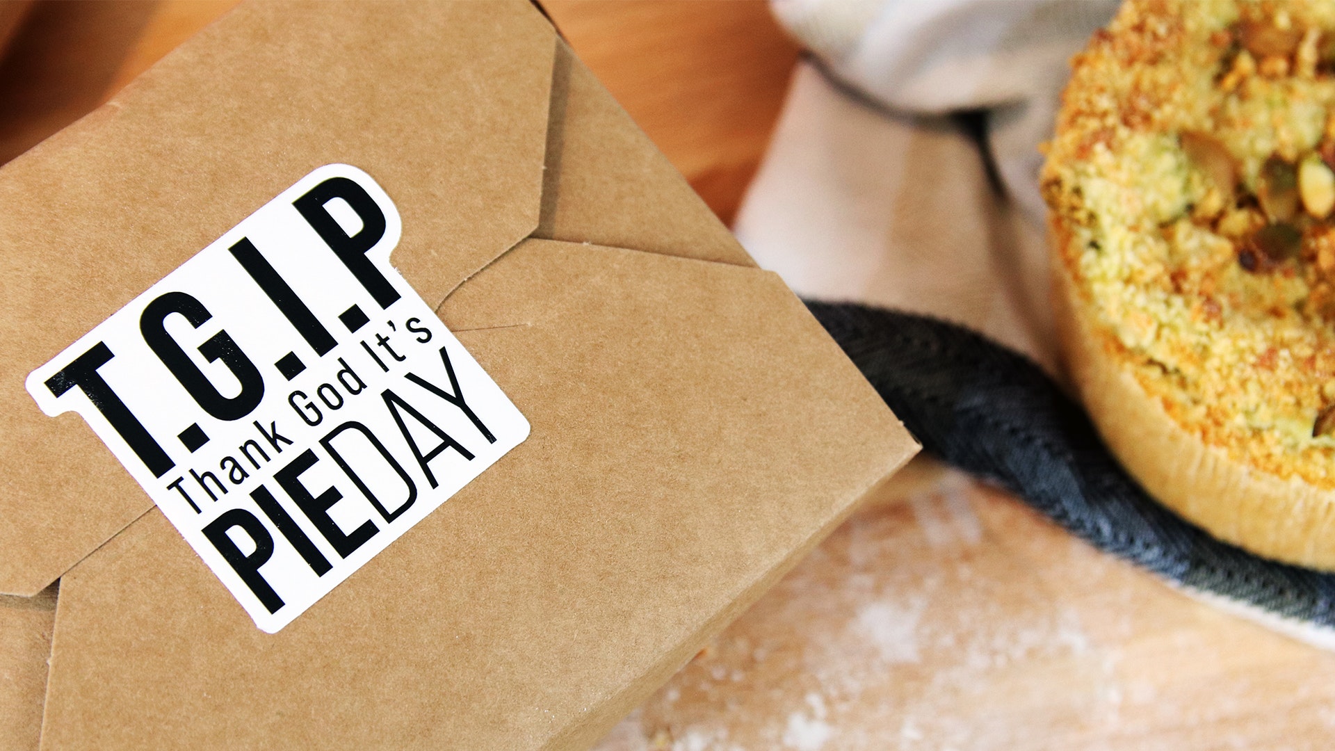 Die cut white vinyl sticker white TGIP design applied to a cardboard food box