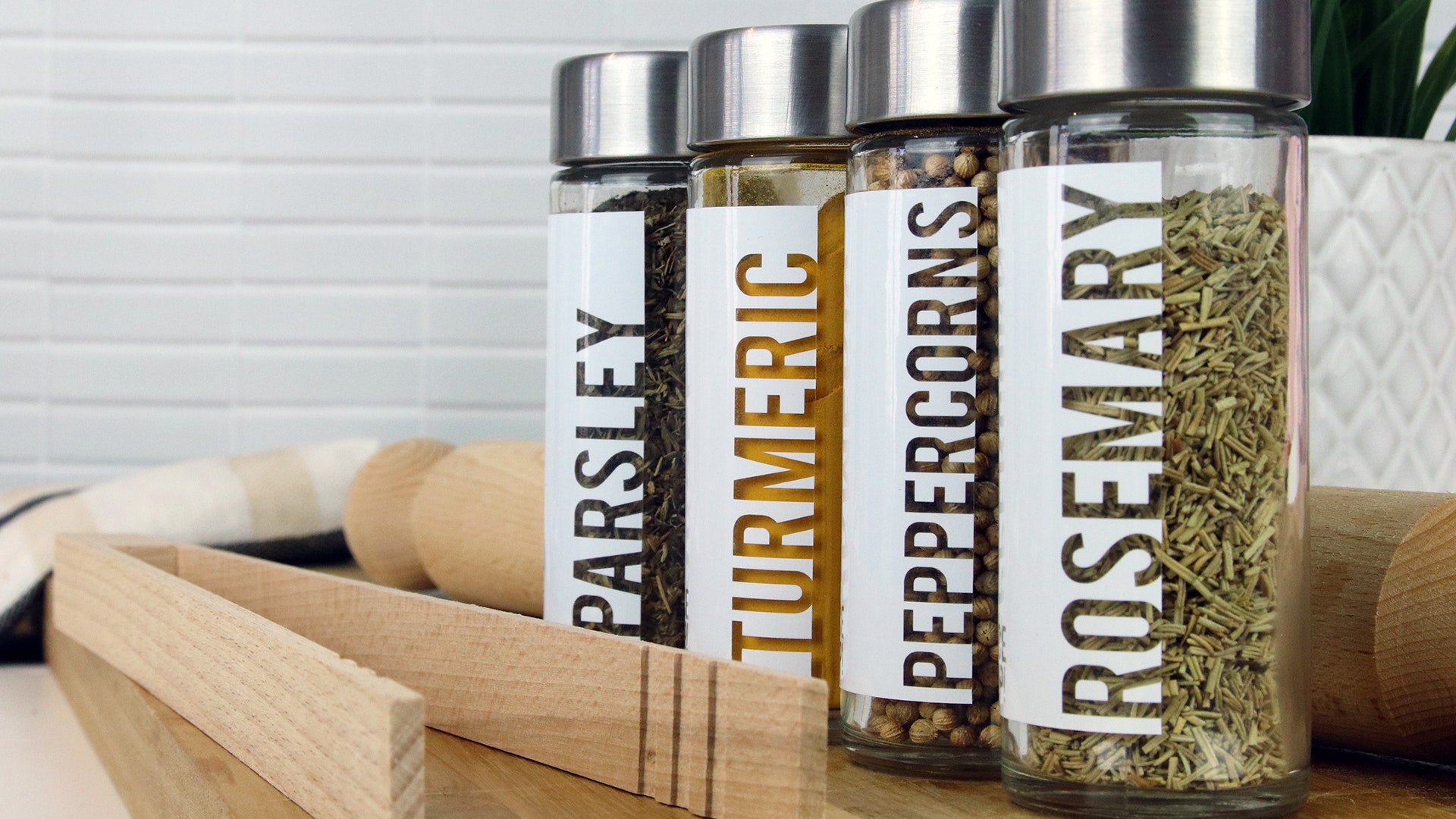 Rectangle clear labels applied to four spice jars filled with different spices
