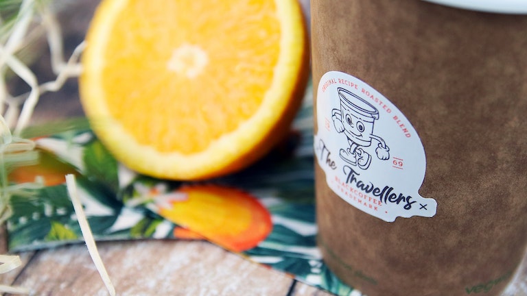 Die cut eco friendly sticker applied to brown paper coffee cup