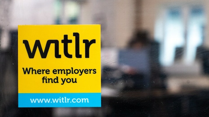 Square front adhesive sticker with witlr logo applied to office door