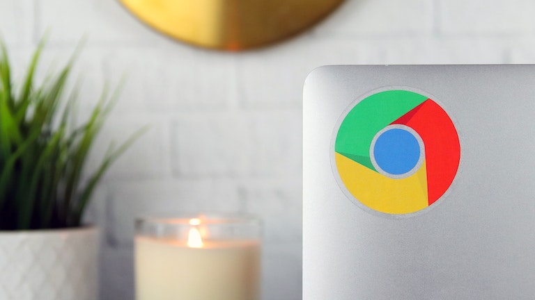 Round clear sticker with Google Chrome design applied to a silver laptop