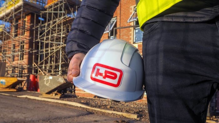 Rounded corner heavy duty sticker with logo applied to a hard hat