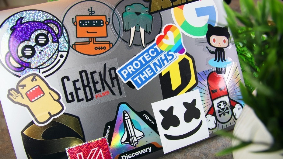 Various stickers applied to a silver laptop