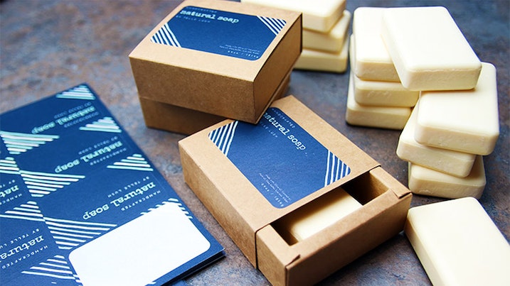 Biodegradable paper sheet labels with rounded corners applied to a cardboard soap box