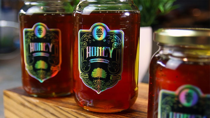 Die cut holographic sheet labels applied to honey jars