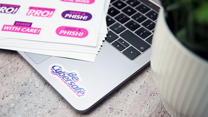 Die cut white vinyl sheet labels with one design applied to a silver laptop