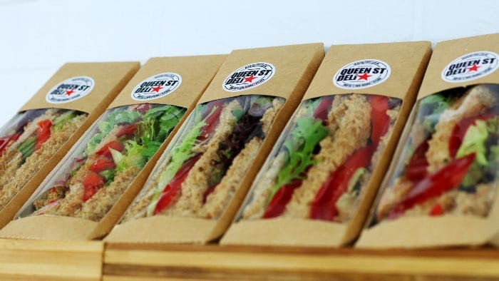 Circle biodegradable paper stickers with logos applied to sandwich packaging