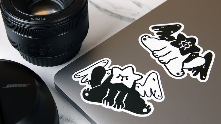Eco-friendly die cut stickers with cat art design applied to a silver laptop
