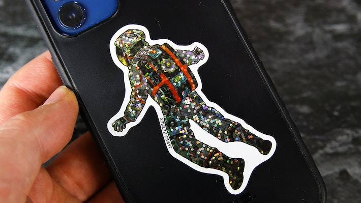 Die cut glitter sticker with James Hersey logo applied to a hand held black phone