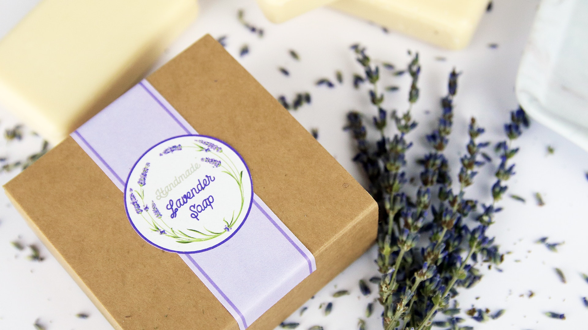 Die cut biodegradable paper stickers applied to a cardboard box filled with lavendar soap