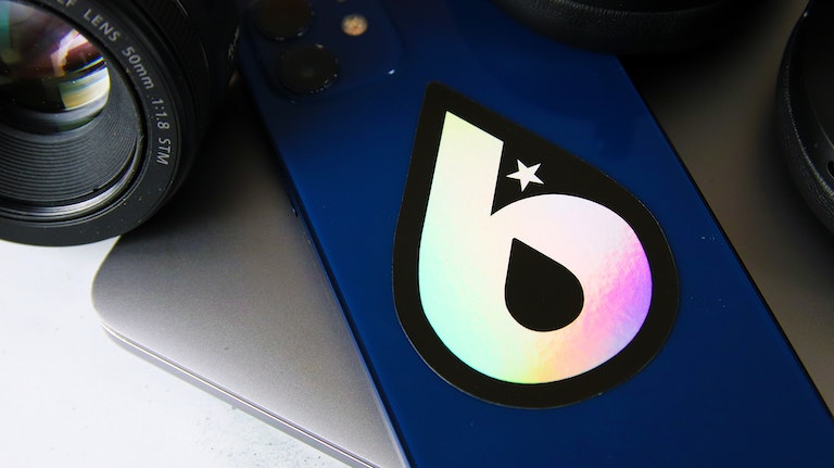 Holographic die cut sticker with logo applied to a blue phone