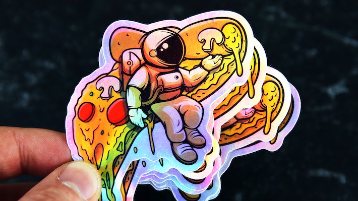 Die cut holographic sticker with pizza astronaut design hand held