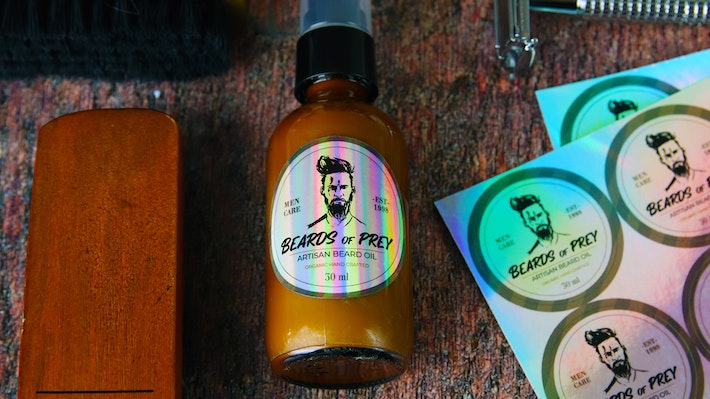Circle holographic sheet labels applied to an amber jar with beard oil