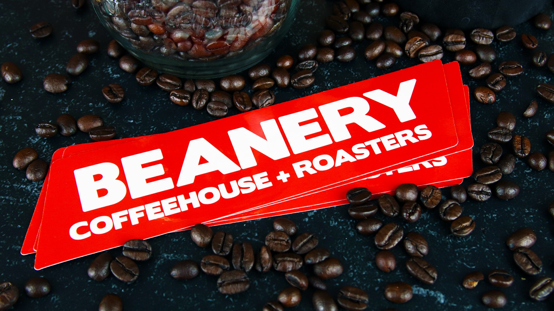 Die cut eco-friendly logo sticker amidst coffee beans