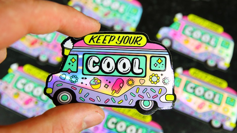 Die cut holographic sticker with old school ice cream van design hand held
