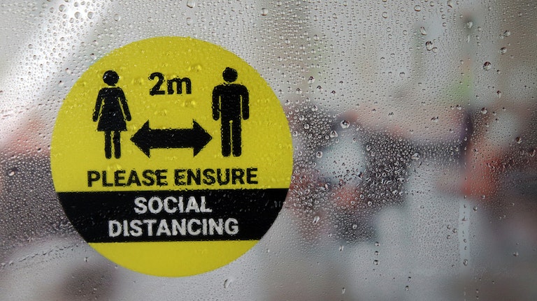 Eco-friendly front adhesive circle sticker with social distancing design applied to a window