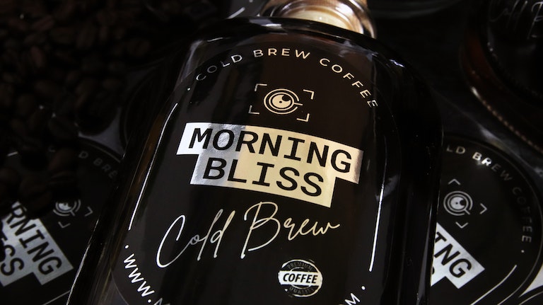 Oval mirror silver label with morning bliss design applied to a glass bottle with cold brew coffee