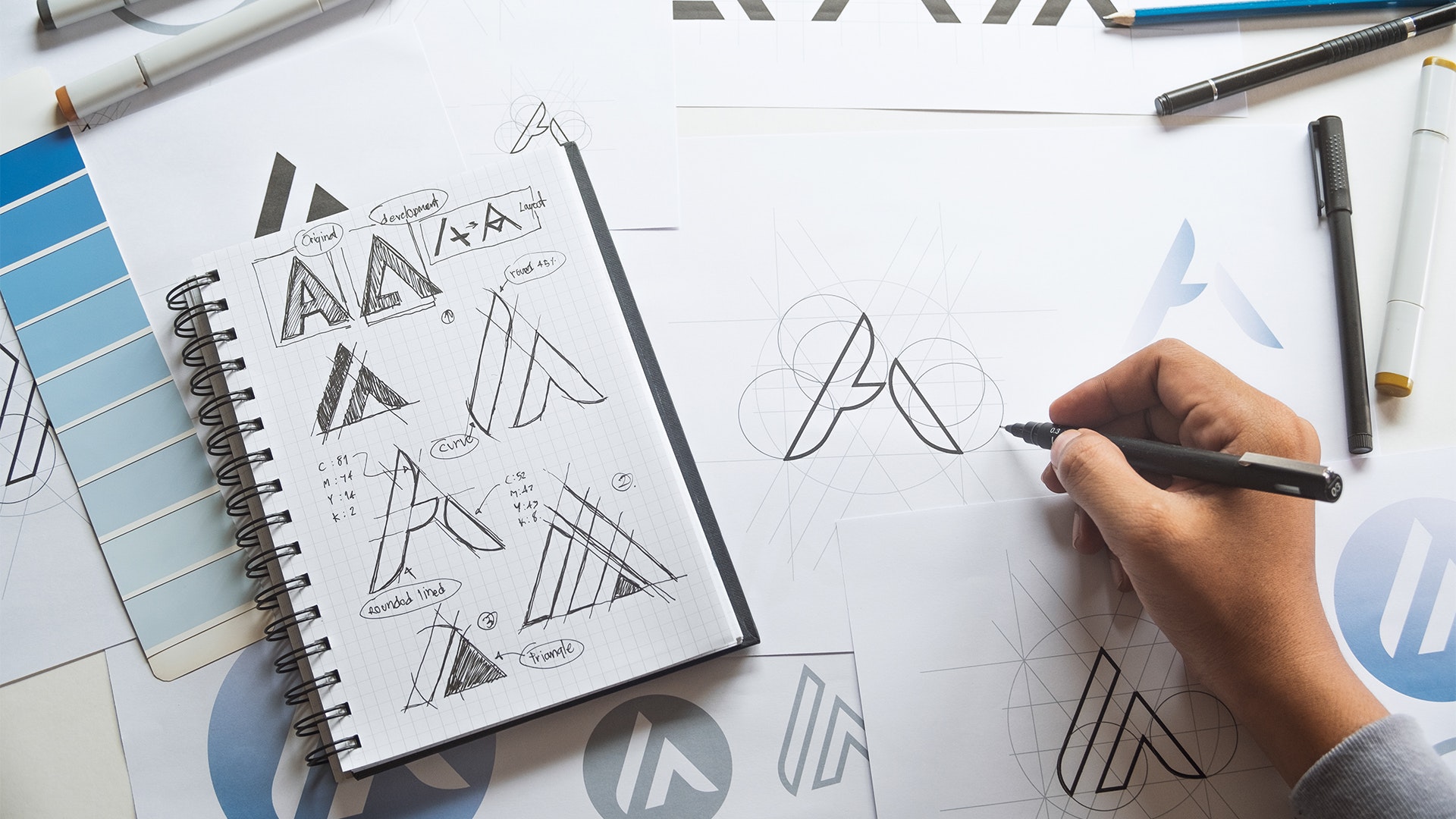 Graphic logo designer sketching ideas in a sketch book