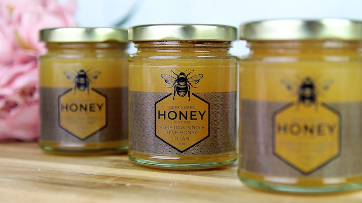 Clear honey jar labels applied to three jars on honey in a row