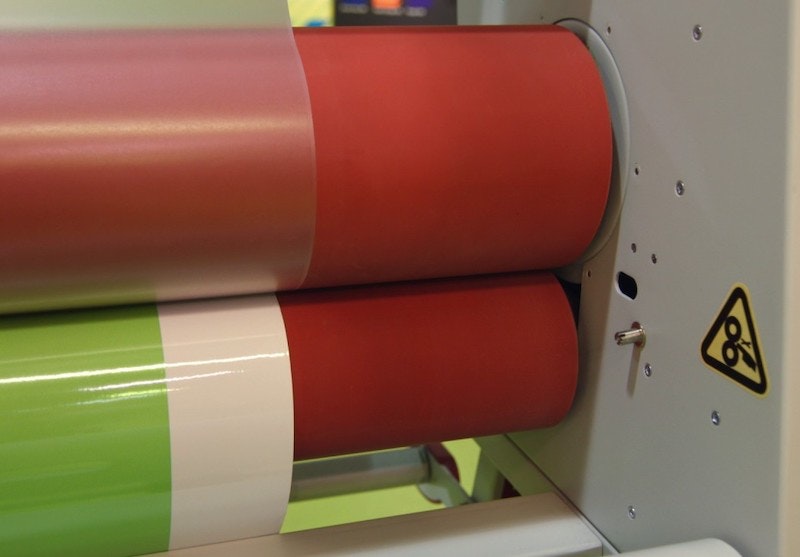 Laminator applying a clear laminate to printed vinyl