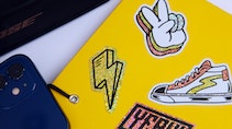 Various die cut eco-friendly glitter stickers with different designs applied to a yellow notebook