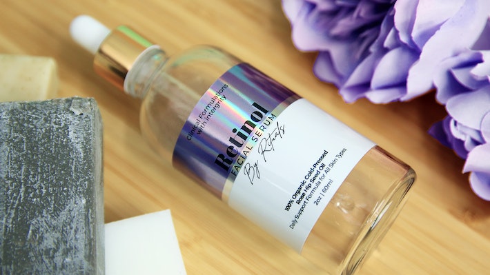 Eco-friendly holographic sticker with retional facial serum logo applied to a clear cosmetics bottle