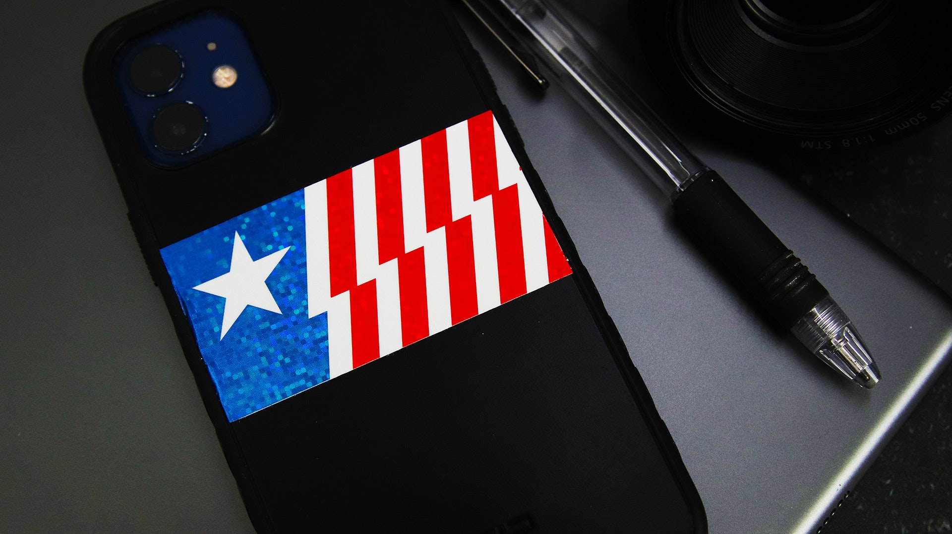 Rectangle glitter sticker with american flag design applied to a black phone
